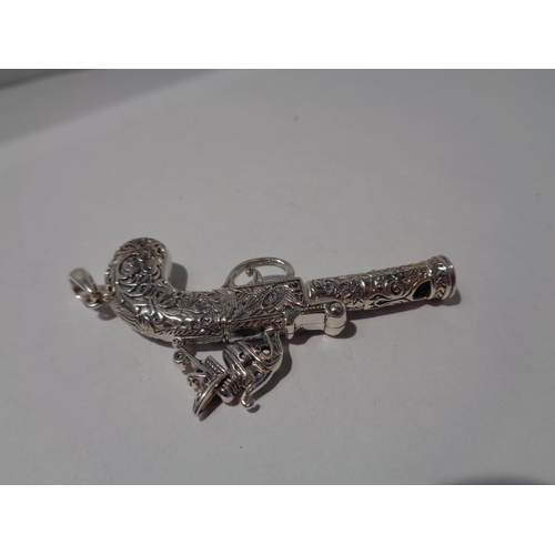 643 - A PENDANT IN THE FORM OF AN ORNATE PISTOL