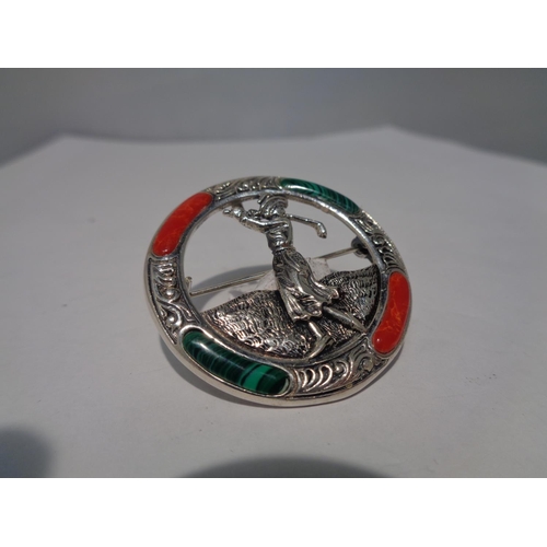 644 - A MARKED SILVER BROOCH WITH GREEN AND RED STONES DEPICTING A LADY GOLFER