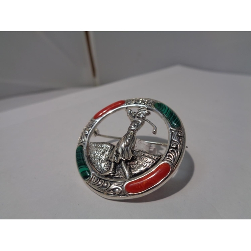 644 - A MARKED SILVER BROOCH WITH GREEN AND RED STONES DEPICTING A LADY GOLFER