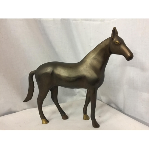 24 - A HEAVY BRONZE EFFECT METAL HORSE FIGURINE, HEIGHT 30CM, WIDTH APPROX 41CM, TOGETHER WITH A BRASS TR... 