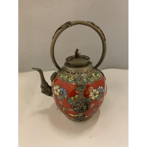 102 - AN ORIENTAL POTTERY AND METAL TEAPOT DECORATED IN RED WITH YELLOW AND BLUE FLOWERS