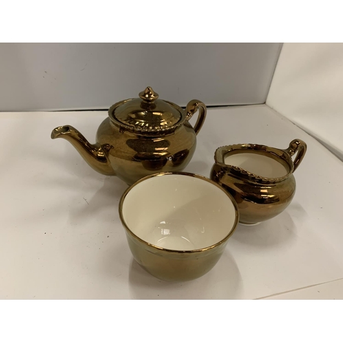 125 - THREE PIECES OF GRAYS GOLD COLOURED POTTERY TO INCLUDE A TEAPOT, JUG AND SUGAR BOWL