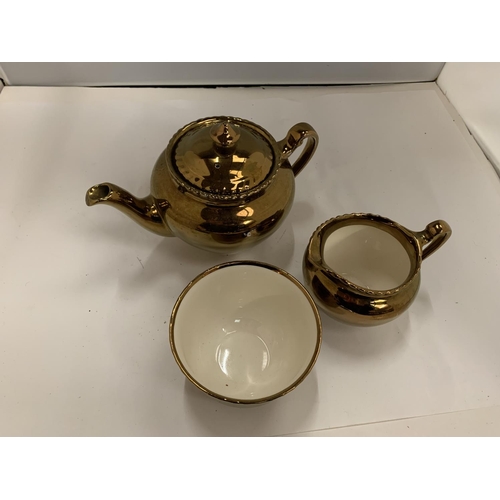 125 - THREE PIECES OF GRAYS GOLD COLOURED POTTERY TO INCLUDE A TEAPOT, JUG AND SUGAR BOWL