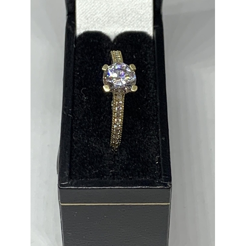 511 - A 9 CARAT GOLD RING WITH A SINGLE CLEAR STONE AND CHIPS ON THE SHOULDERS SIZE O/P IN A PRESENTATION ... 