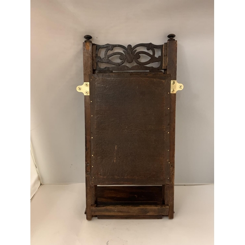 98 - A WOODEN WALL MIRROR WITH A DECORATIVE TOP AND A SHELF