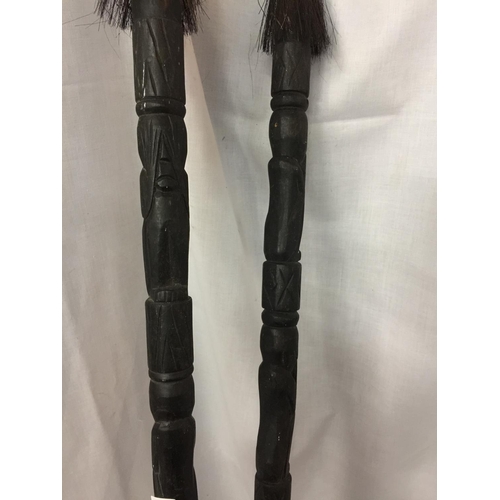 430 - TWO CARVED WOODEN SPEARS WITH DETACHABLE COVERS