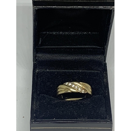 520 - A 9 CARAT GOLD RING WITH SIX DIAMONDS IN A TWIST DESIGN SIZE R IN A PRESENTATION BOX