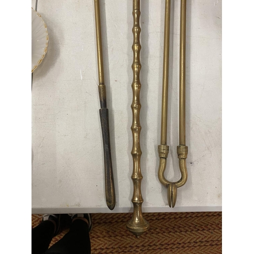 215 - A SET OF BRASS FIRESIDE ITEMS TO INCLUDE, A POKER, TONGS AND A SHOVEL, SIZE 74CM