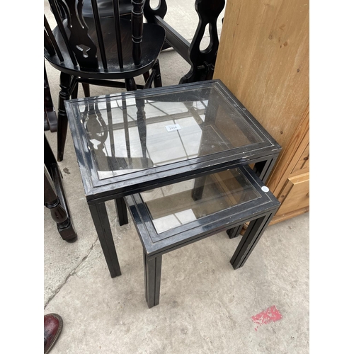 2456 - TWO SMALL EBONISED GLASS TOP TABLES