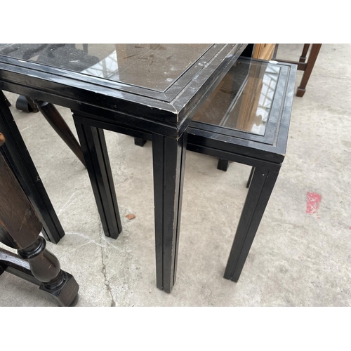 2456 - TWO SMALL EBONISED GLASS TOP TABLES