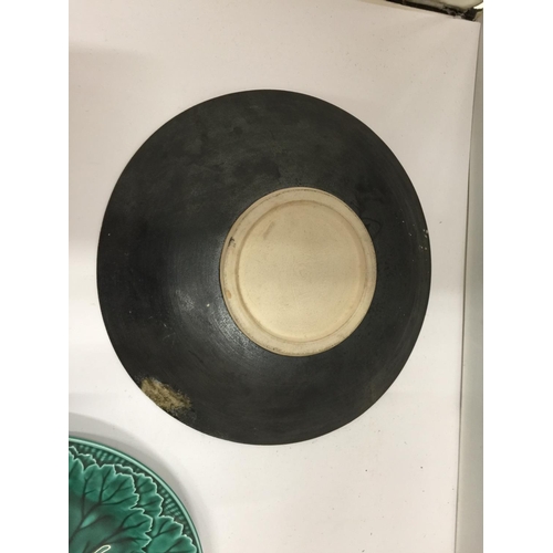 67 - TWO COLLECTABLE PLATES, ONE A GREEN WEDGWOOD CABBAGE LEAF PLUS A STUDIO POTTERY PLATE WITH A BIRD DE... 