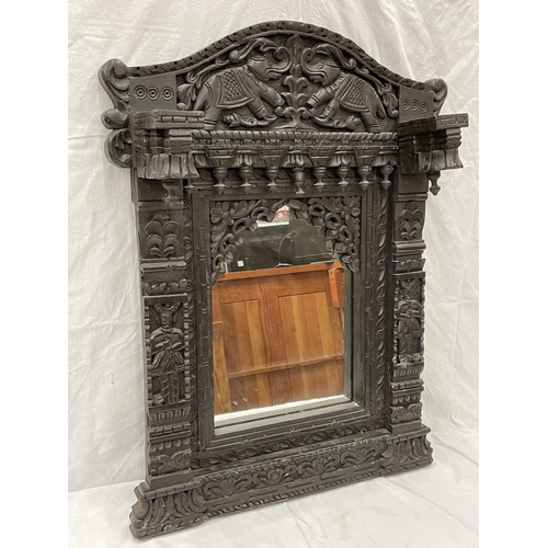 18 - A HEAVILY CARVED EBONY ASIAN STYLE MIRROR WITH ELEPHANT DETAIL 52CM X 79CM