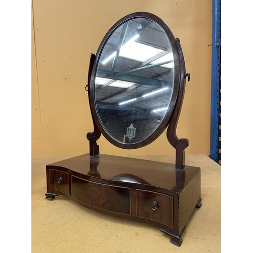 43A - A MAHOGANY OVAL DRESSING TABLE MIRROR WITH A SERPENTINE BOW FRONT CONTAINING ONE LONG AND TWO SHORT ... 