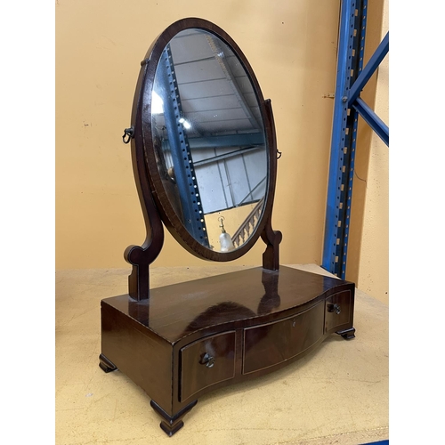 43A - A MAHOGANY OVAL DRESSING TABLE MIRROR WITH A SERPENTINE BOW FRONT CONTAINING ONE LONG AND TWO SHORT ... 