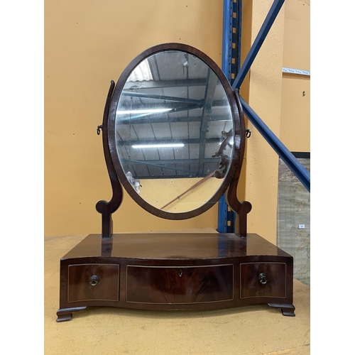 43A - A MAHOGANY OVAL DRESSING TABLE MIRROR WITH A SERPENTINE BOW FRONT CONTAINING ONE LONG AND TWO SHORT ... 