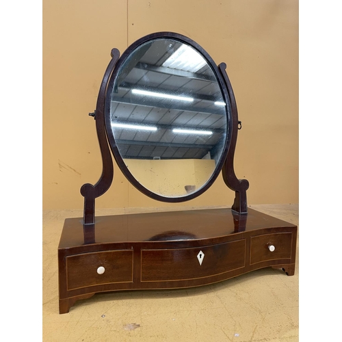 44A - A MAHOGANY OVAL DRESSING TABLE MIRROR WITH A SERPENTINE BOW FRONT CONTAINING ONE LONG AND TWO SHORT ... 