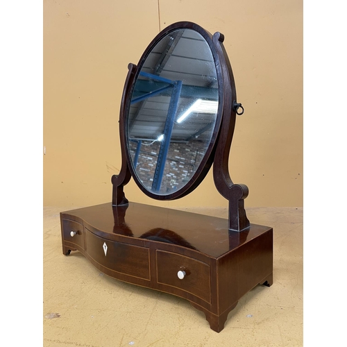 44A - A MAHOGANY OVAL DRESSING TABLE MIRROR WITH A SERPENTINE BOW FRONT CONTAINING ONE LONG AND TWO SHORT ... 