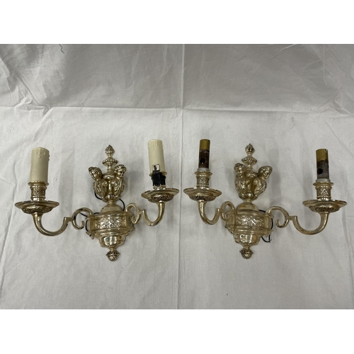 45 - A PAIR OF WHITE METAL DOUBLE WALL LIGHTS WITH CHERUB STYLE DESIGN