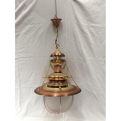 56 - AN UNUSUAL BRASS AND COPPER PENDANT LIGHT WITH DOMED GLASS SHADE, SHIPS WHEEL DESIGN AND CHAINS