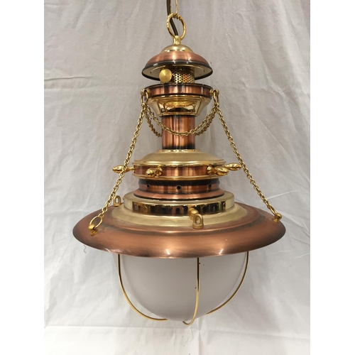 56 - AN UNUSUAL BRASS AND COPPER PENDANT LIGHT WITH DOMED GLASS SHADE, SHIPS WHEEL DESIGN AND CHAINS