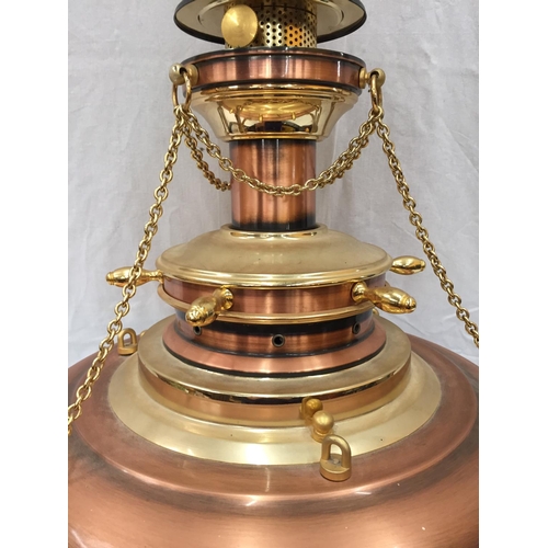 56 - AN UNUSUAL BRASS AND COPPER PENDANT LIGHT WITH DOMED GLASS SHADE, SHIPS WHEEL DESIGN AND CHAINS