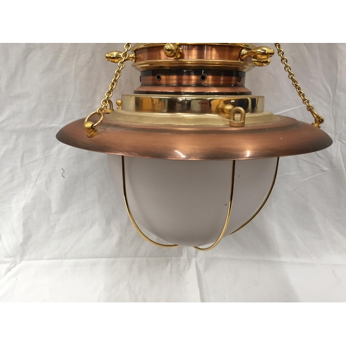 56 - AN UNUSUAL BRASS AND COPPER PENDANT LIGHT WITH DOMED GLASS SHADE, SHIPS WHEEL DESIGN AND CHAINS