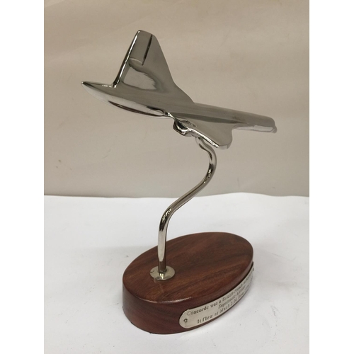 93 - A CHROME REPLICA OF CONCORDE ON A WOODEN STAND 19CM X 21CM