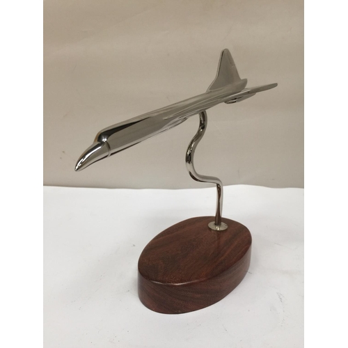 93 - A CHROME REPLICA OF CONCORDE ON A WOODEN STAND 19CM X 21CM