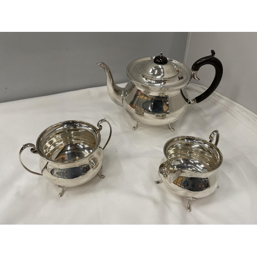 1 - A THREE PIECE HALLMARKED BIRMINGHAM SILVER TEA SET TO INCLUDE A TEAPOT, TWIN HANDLED SUGAR BOWL AND ... 