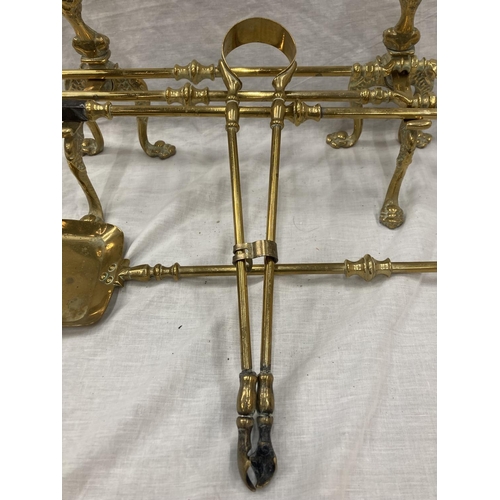 35 - A PAIR OF BRASS FIRE DOGS WITH BALL AND CLAW DECORATION PLUS A BRASS COMPANION SET