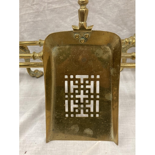 35 - A PAIR OF BRASS FIRE DOGS WITH BALL AND CLAW DECORATION PLUS A BRASS COMPANION SET