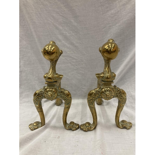 35 - A PAIR OF BRASS FIRE DOGS WITH BALL AND CLAW DECORATION PLUS A BRASS COMPANION SET