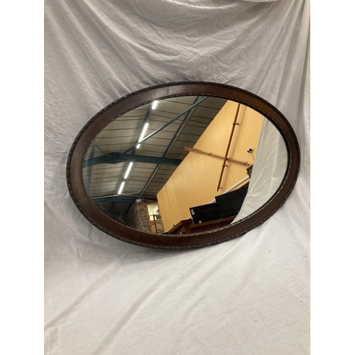 42 - A LARGE MAHOGANY FRAMED OVAL MIRROR WITH BEADED INNER APPROX 100CM X 65CM