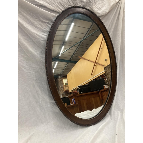 42 - A LARGE MAHOGANY FRAMED OVAL MIRROR WITH BEADED INNER APPROX 100CM X 65CM