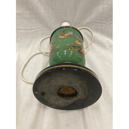 24 - A GREEN CERAMIC LAMP EMBOSSED WITH A FLOWER AND BUTTERFLY DESIGN