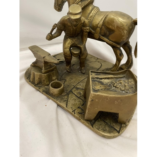 168 - A HEAVY BRASS SHIRE HORSE AT A BLACKSMITHS HEIGHT 18.5CM, WIDTH 20.5CM, LENGTH 24CM