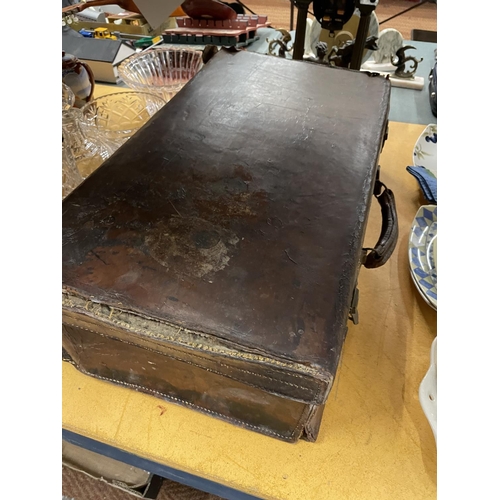 490 - A VINTAGE LEATHER SUITCASE IN NEED OF RESTORATION