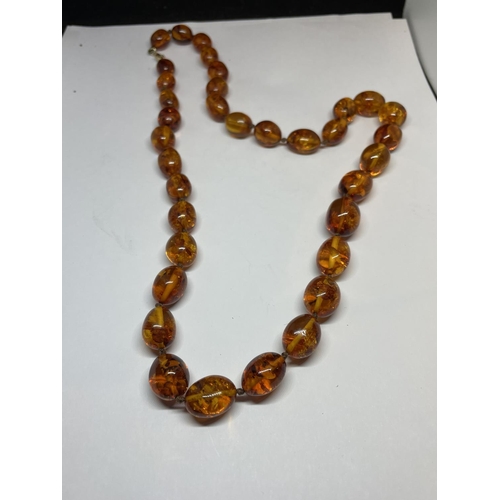 521 - A KNOTTED AMBER NECKLACE WITH A MARKED 9K CLASP