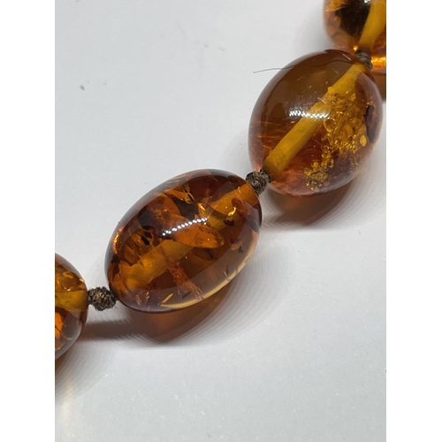 521 - A KNOTTED AMBER NECKLACE WITH A MARKED 9K CLASP