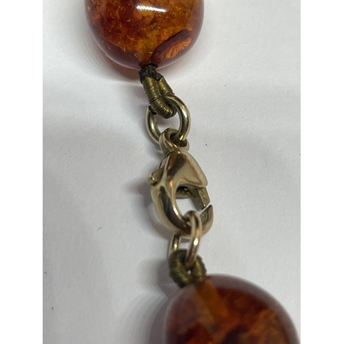 521 - A KNOTTED AMBER NECKLACE WITH A MARKED 9K CLASP