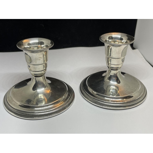 523 - A PAIR OF SILVER MARKED 830S CANDLESTICKS WITH WEIGHTED BASES