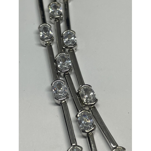 531 - A TRIPLE STRAND SILVER BRACELET WITH CLEAR STONE DECORATION IN A PRESENTATION BOX