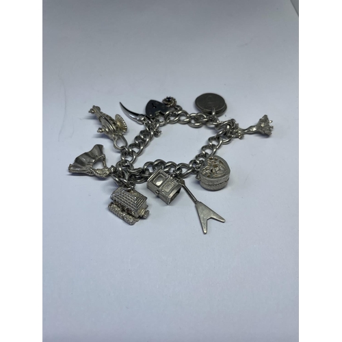 533 - A MARKED SILVER CHARM BRACELET WITH TEN CHARMS TO INCLUDE A FLAMENCO DANCER, MATADOR, HOUSE, OIL LAM... 