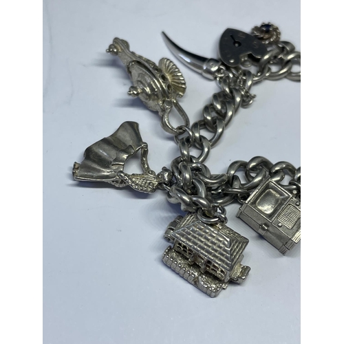 533 - A MARKED SILVER CHARM BRACELET WITH TEN CHARMS TO INCLUDE A FLAMENCO DANCER, MATADOR, HOUSE, OIL LAM... 