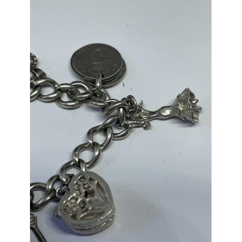 533 - A MARKED SILVER CHARM BRACELET WITH TEN CHARMS TO INCLUDE A FLAMENCO DANCER, MATADOR, HOUSE, OIL LAM... 