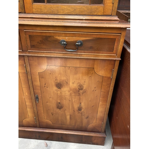 2460 - A MODERN YEW WOOD GLASED BOOKCASE ON BASE 56