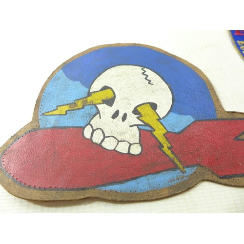 326 - A PAINTED LEATHER PATCH WITH SKULL AND BOMB DECORATION, SHOOTING PATCH