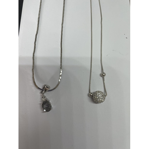 516 - FOUR MARKED SILVER NECKLACES WITH PENDANTS TO INCLUDE A CLEAR STONE BALL AND A GREEN STONE