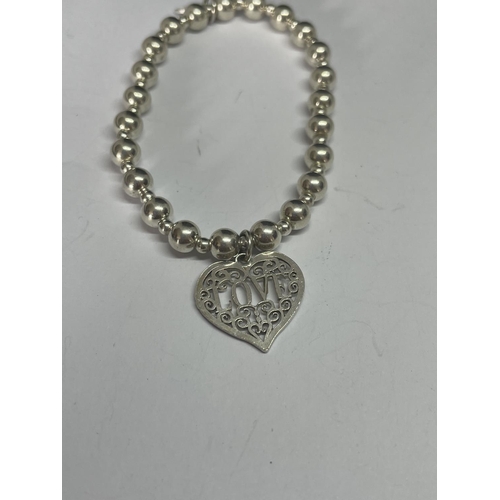 534 - A MARKED SILVER BALL DESIGN NECKLACE AND BRACELET WITH A HEART DESIGN CHARM