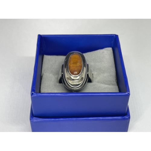 615 - A SILVER AND AMBER OVAL RING IN A PRESENTATION BOX